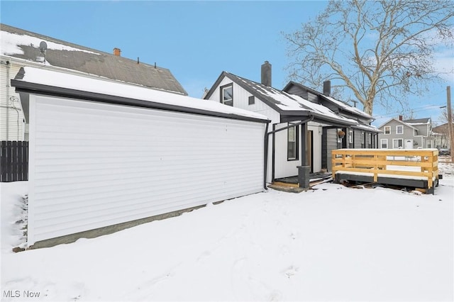 snow covered property with fence and a deck