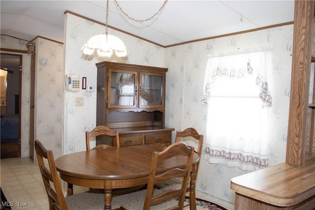 dining area featuring ornamental molding, tile patterned floors, lofted ceiling, and wallpapered walls