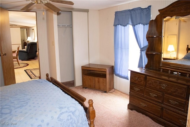 bedroom featuring light colored carpet, ceiling fan, and multiple windows