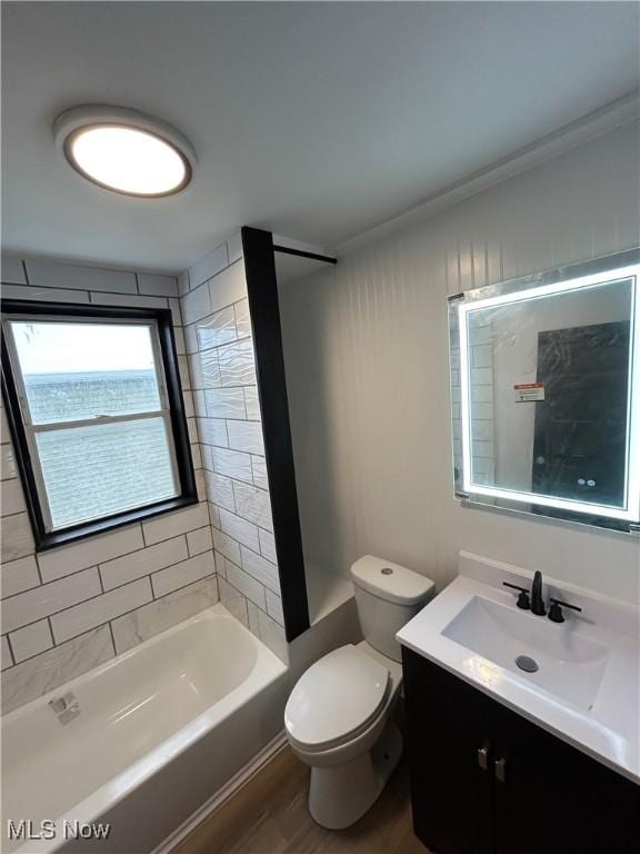 bathroom featuring toilet, shower / bathtub combination, wood finished floors, and vanity