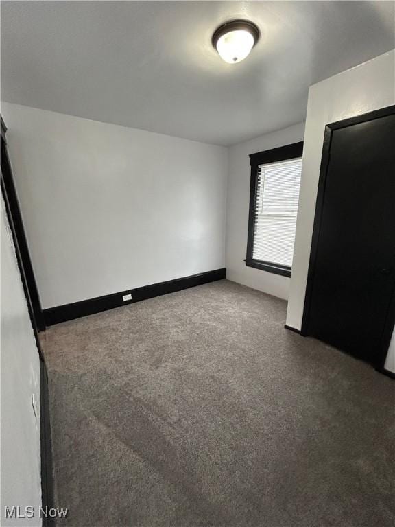 unfurnished bedroom featuring carpet and baseboards