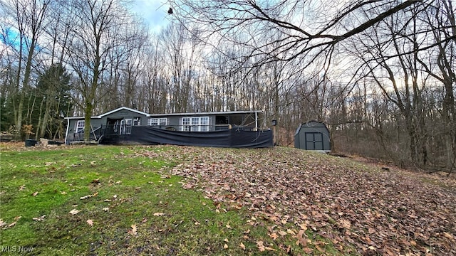 exterior space with an outbuilding, a storage unit, and a front lawn