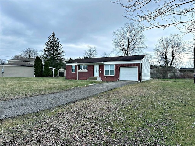 single story home featuring driveway, brick siding, an attached garage, and a front yard