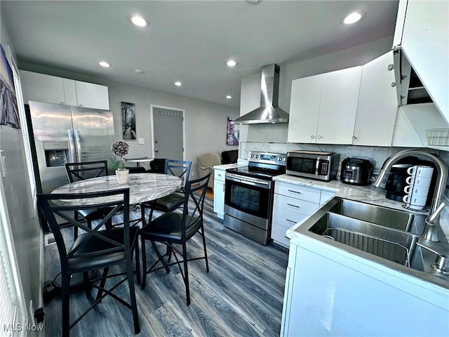 kitchen featuring extractor fan, a sink, white cabinets, light countertops, and appliances with stainless steel finishes