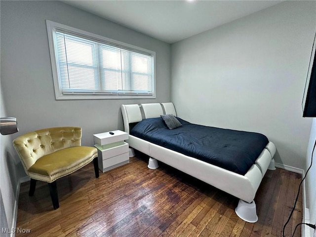 bedroom featuring baseboards and dark wood-type flooring