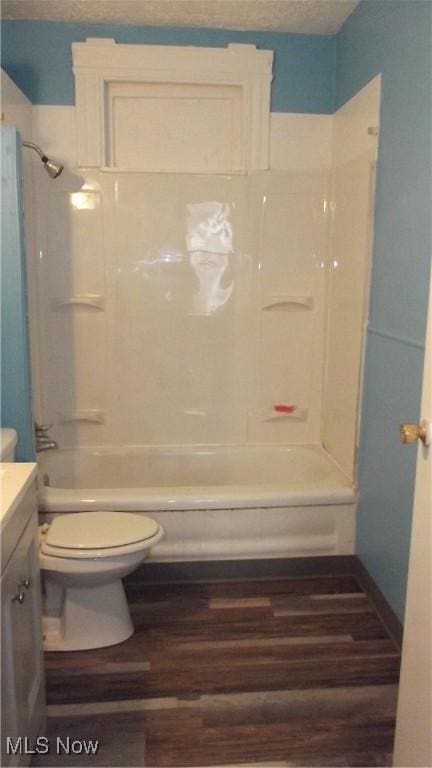 bathroom with bathing tub / shower combination, vanity, toilet, and wood finished floors