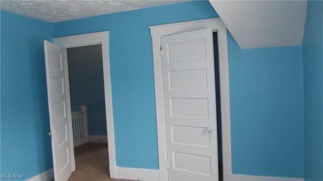 unfurnished bedroom featuring baseboards and a textured ceiling