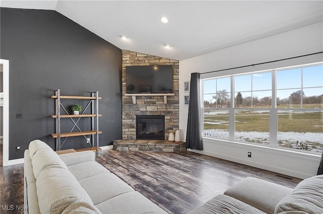 living area featuring dark wood-type flooring, lofted ceiling, a fireplace, and baseboards