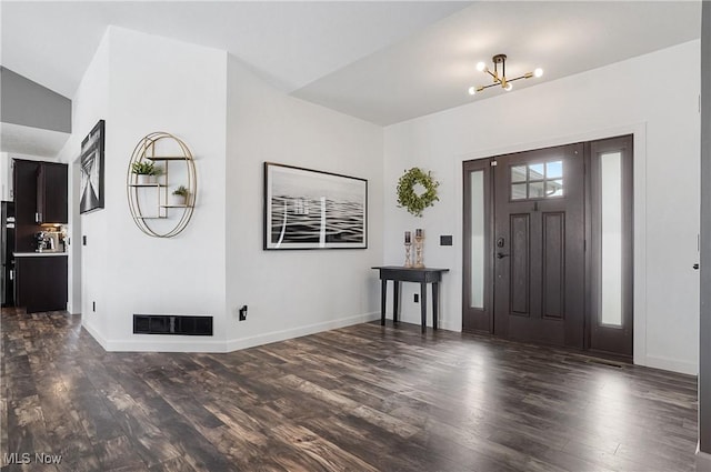 entrance foyer featuring a chandelier, dark wood-style flooring, visible vents, and baseboards