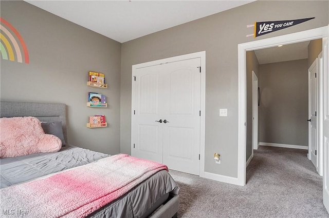 bedroom with a closet, carpet flooring, and baseboards