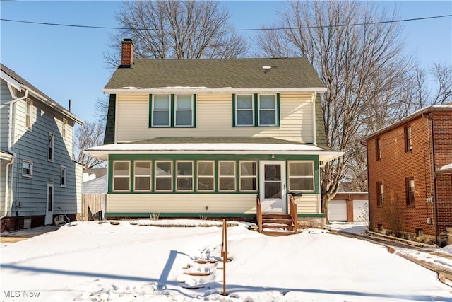 view of front of house with a shingled roof and a chimney