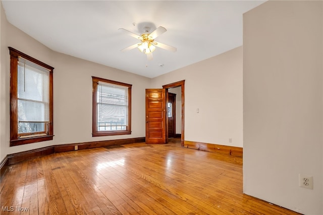 empty room with light wood-style floors, baseboards, and a ceiling fan