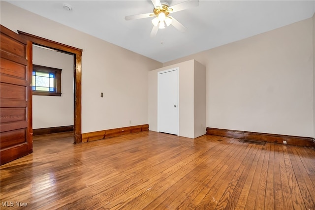 unfurnished room with light wood finished floors, baseboards, and visible vents