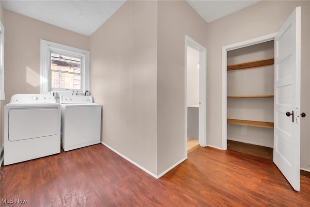 laundry area with laundry area, washer and clothes dryer, wood finished floors, and baseboards