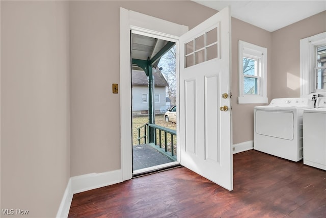 washroom with baseboards, laundry area, dark wood-type flooring, and washer and dryer