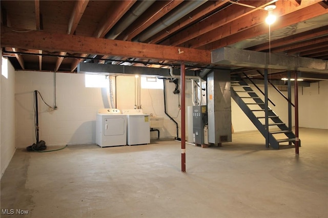 basement with heating unit, washing machine and dryer, and stairs