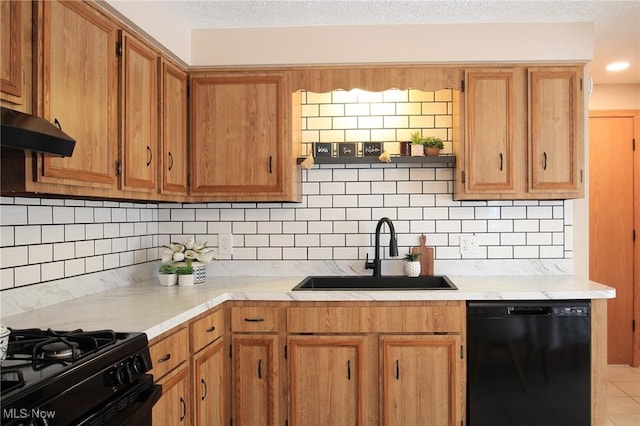 kitchen with black dishwasher, light countertops, a textured ceiling, under cabinet range hood, and a sink