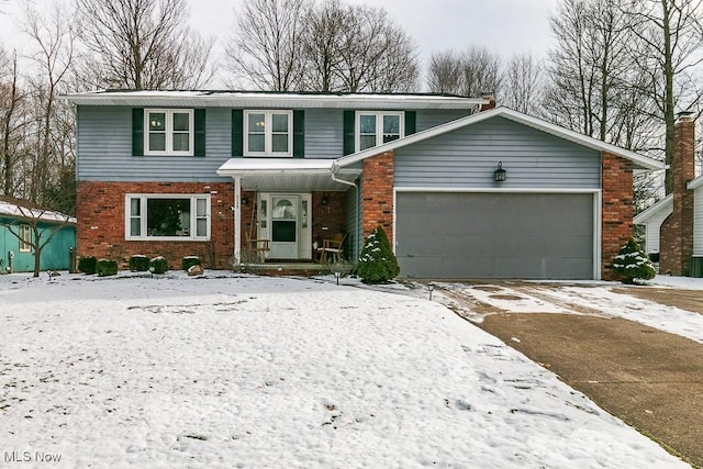 view of front of home with an attached garage, driveway, and brick siding