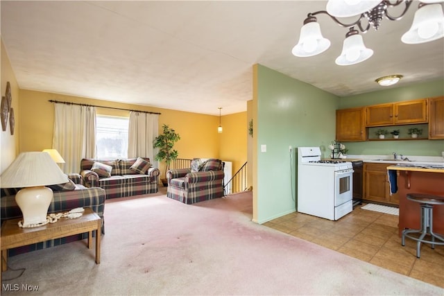 kitchen featuring brown cabinets, decorative light fixtures, light countertops, open floor plan, and white gas range oven