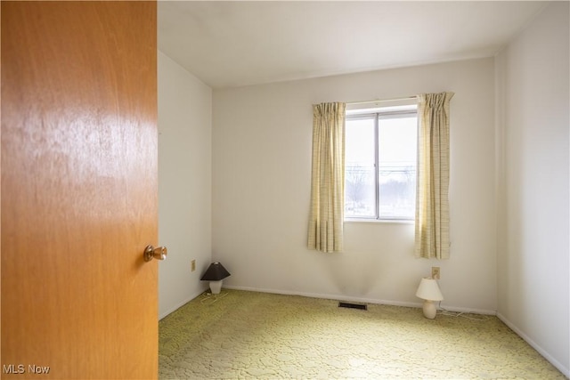 unfurnished room featuring carpet, visible vents, and baseboards