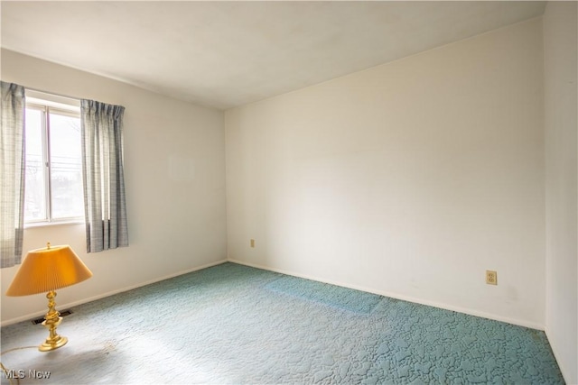 carpeted spare room with baseboards and visible vents