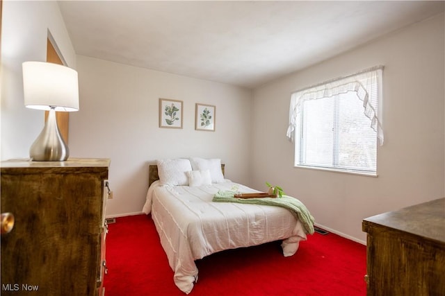 bedroom featuring dark carpet and baseboards