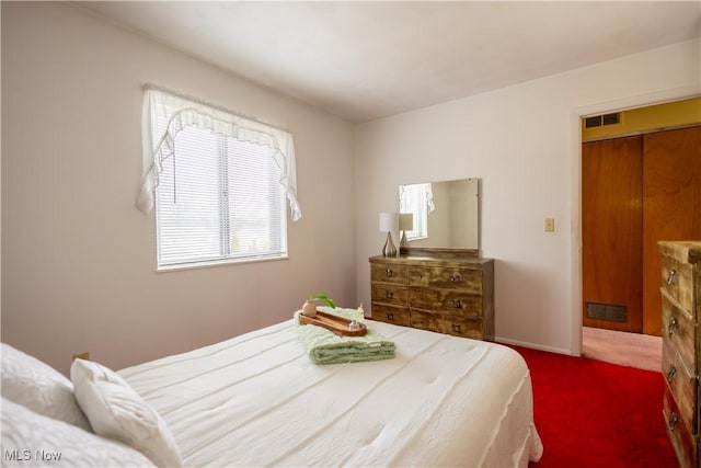 carpeted bedroom with visible vents and baseboards