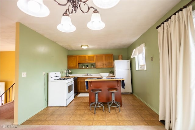 kitchen featuring white appliances, hanging light fixtures, light countertops, a kitchen bar, and a chandelier