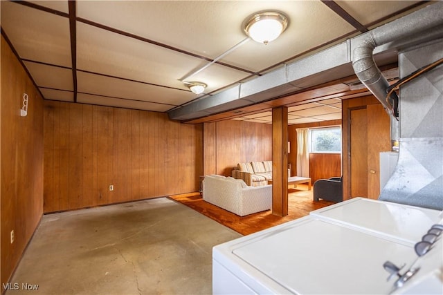 basement featuring wood walls and washer and dryer