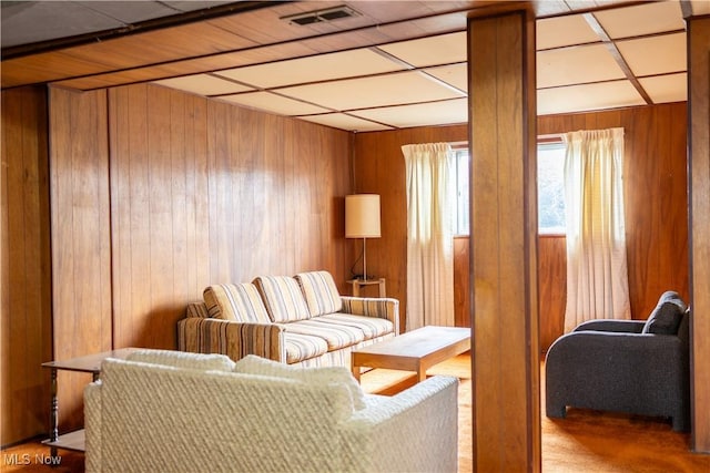 living area featuring wood walls and visible vents