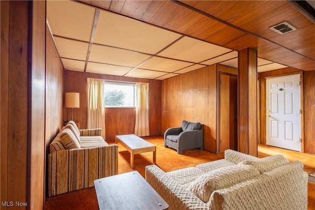 living area with wooden walls and visible vents