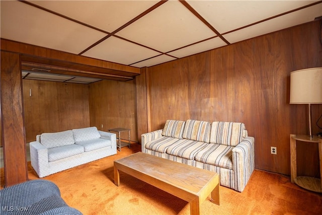 carpeted living room featuring wood walls