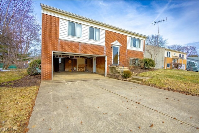 bi-level home with a garage, driveway, brick siding, and a front yard