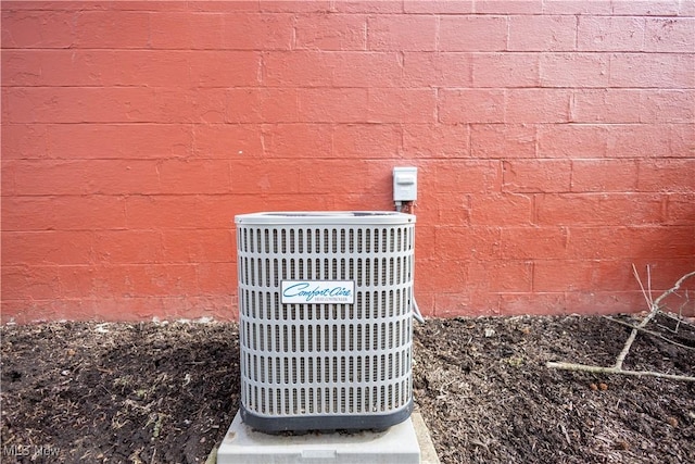 details with central AC unit, concrete block siding, and brick siding