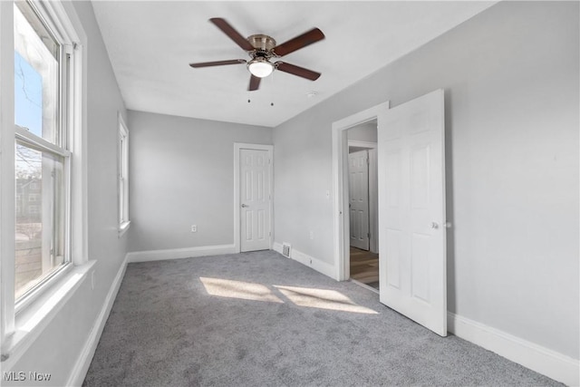 unfurnished bedroom featuring a ceiling fan, visible vents, baseboards, and carpet flooring