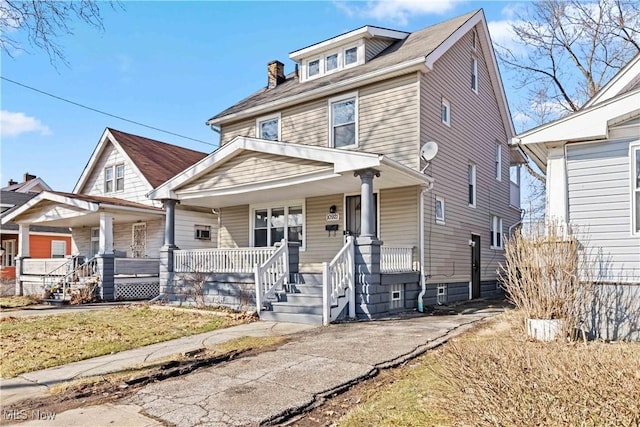 american foursquare style home with covered porch