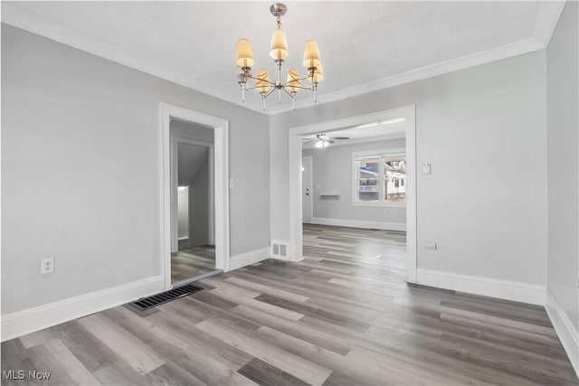 unfurnished dining area featuring ornamental molding, visible vents, baseboards, and wood finished floors