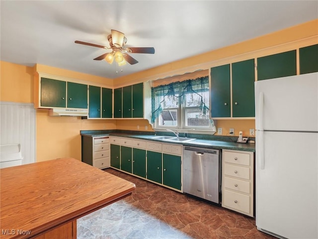 kitchen featuring a sink, green cabinets, freestanding refrigerator, dishwasher, and dark countertops