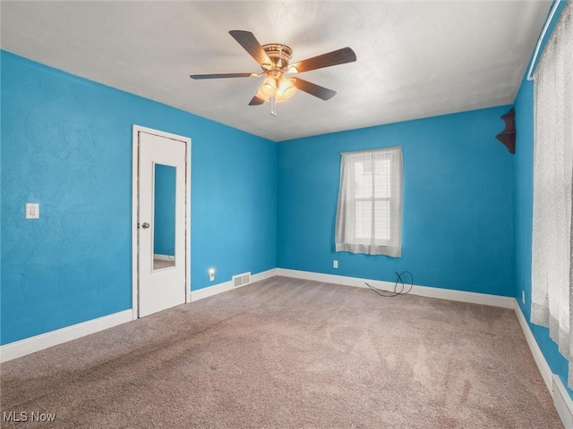 unfurnished room featuring carpet, visible vents, ceiling fan, and baseboards