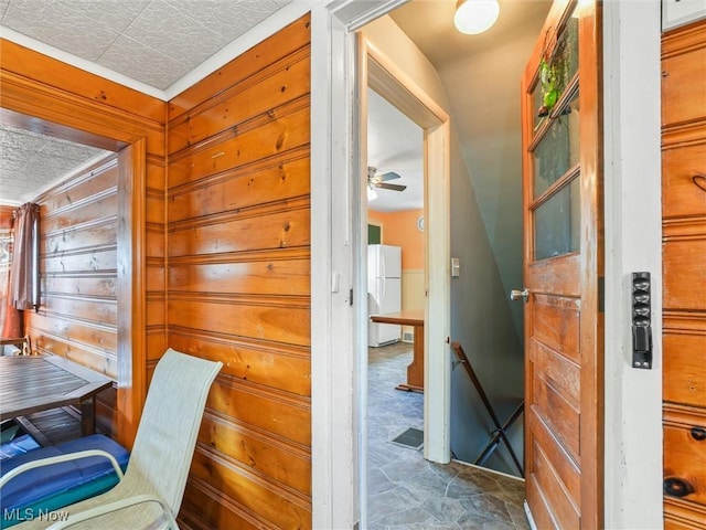 home office featuring wood walls and ceiling fan