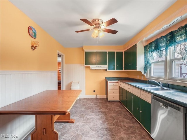 kitchen with a sink, green cabinets, wainscoting, dishwasher, and dark countertops