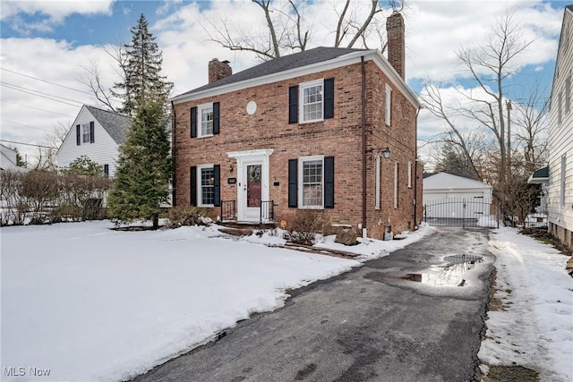 view of front of property featuring a garage, a chimney, and brick siding