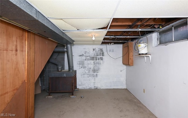 unfinished basement featuring a wood stove