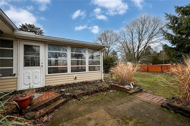 view of side of property with fence and a lawn