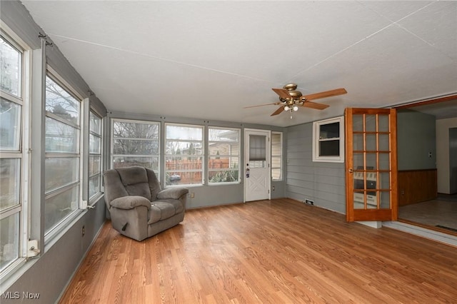 unfurnished sunroom featuring ceiling fan