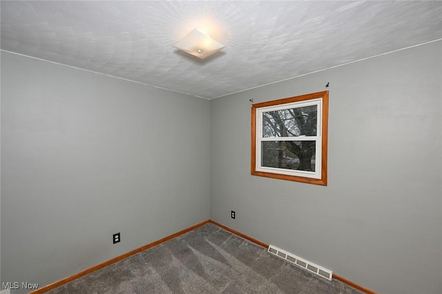 carpeted empty room with visible vents, a textured ceiling, and baseboards