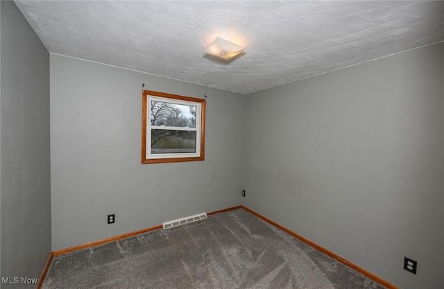 carpeted spare room featuring a textured ceiling, visible vents, and baseboards