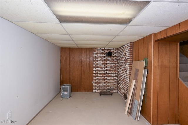 finished below grade area featuring a paneled ceiling and wooden walls