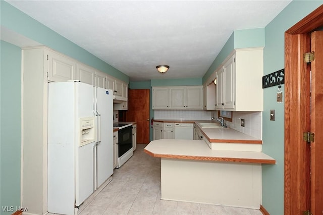 kitchen with light countertops, white cabinets, a sink, white appliances, and a peninsula