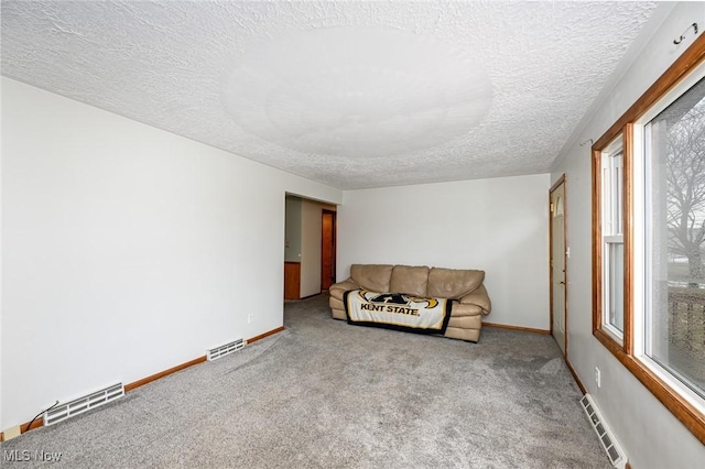 living room with light carpet, visible vents, and baseboards